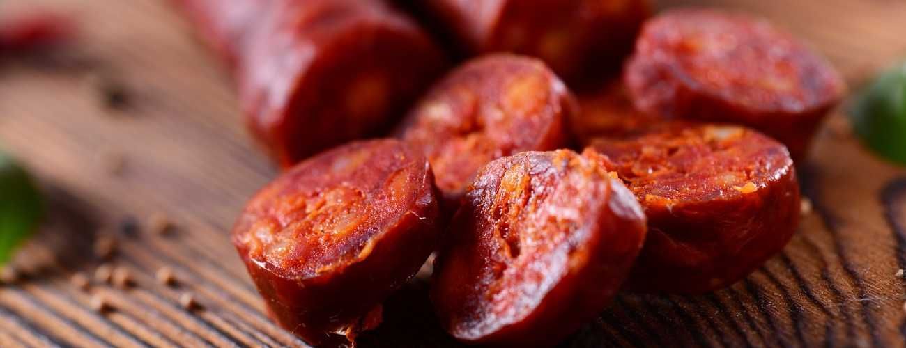Un montón de chorizos están sobre una mesa de madera.