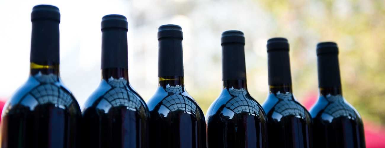 Una fila de botellas de vino están alineadas en una fila.