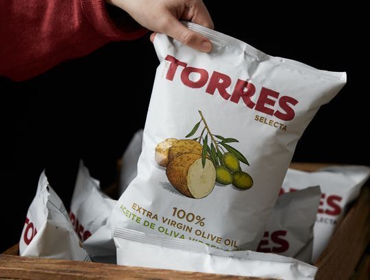Una persona sostiene una bolsa de patatas fritas Torres.