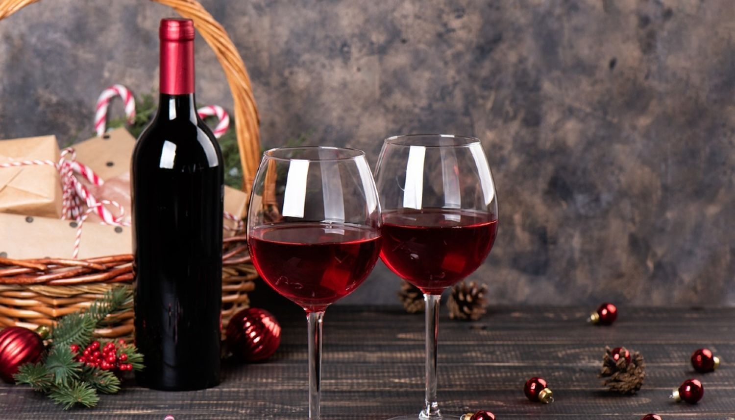 Hay una botella de vino y dos copas de vino en la mesa.