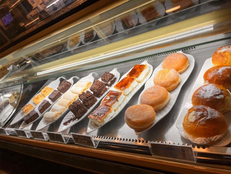 Vitrina con pasteles: brownies, pasteles rellenos de crema, donuts y bollos.