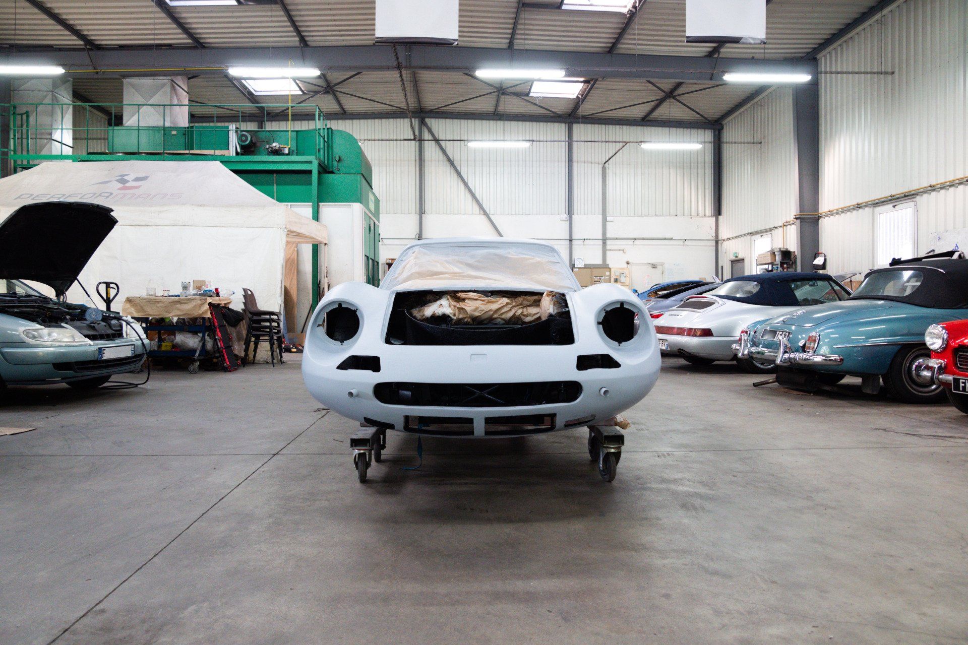 Carrosserie de voiture exposée au milieu du garage