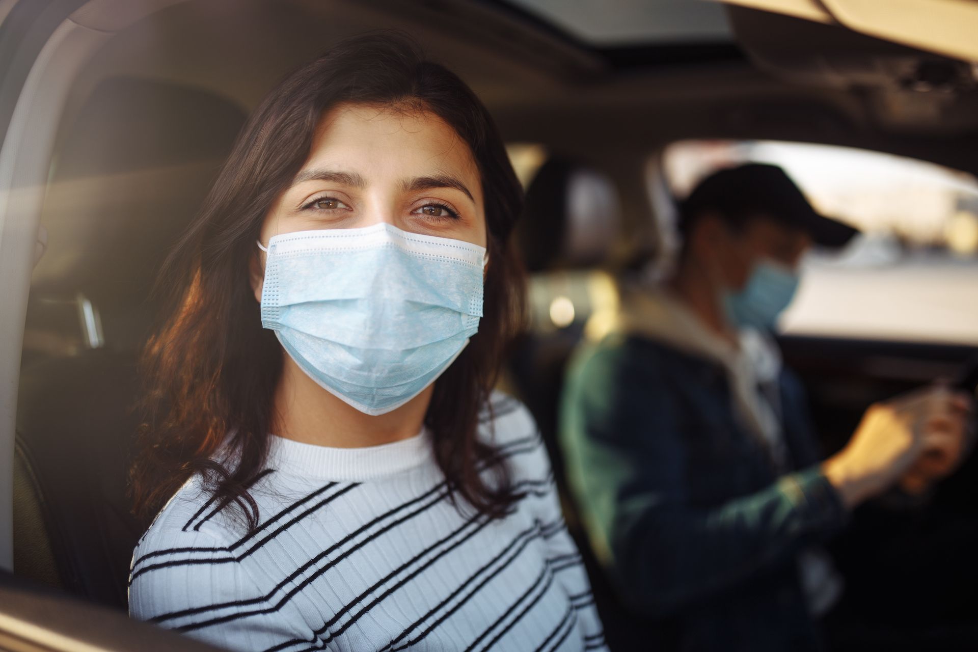Une dame portant un masque dans une voiture