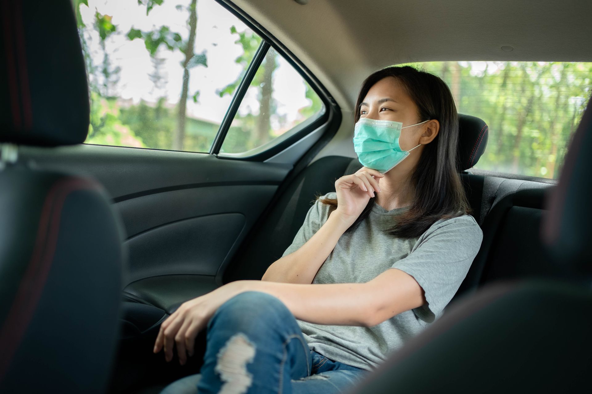 Une femme se touchant le menton à l'arrière d'un véhicule