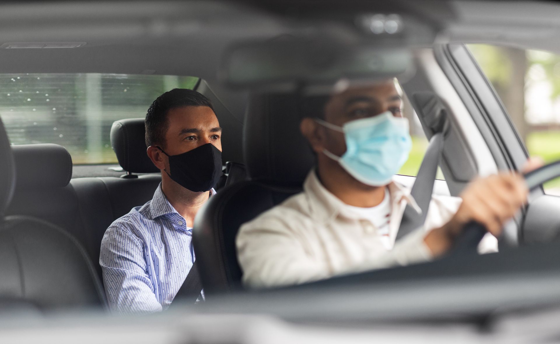 Des hommes protégés par un masque dans une voiture