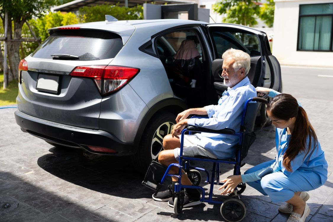 Un homme en fauteuil à côté d'une voiture