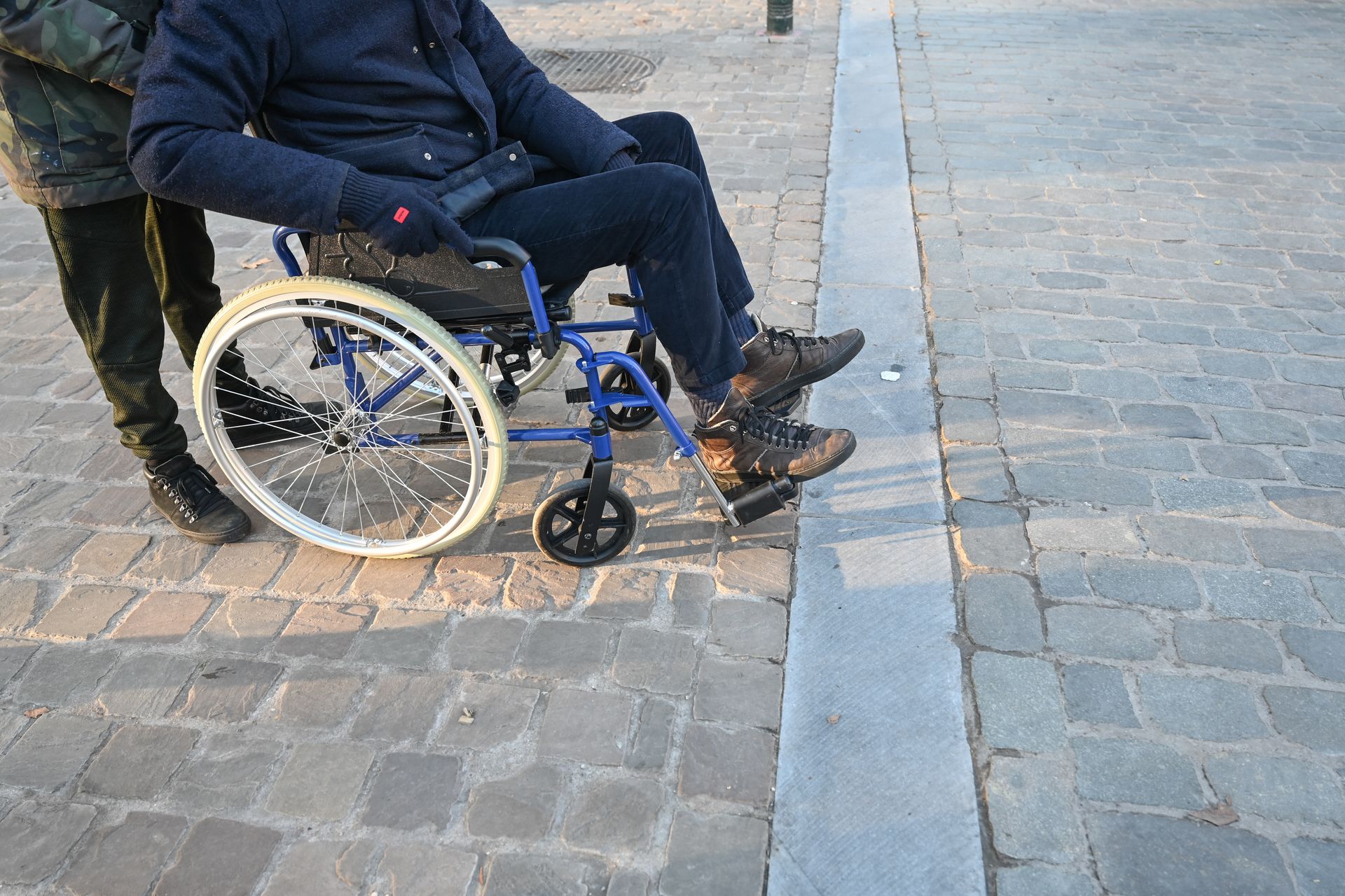 Un homme dans un fauteuil roulant sur le trottoir
