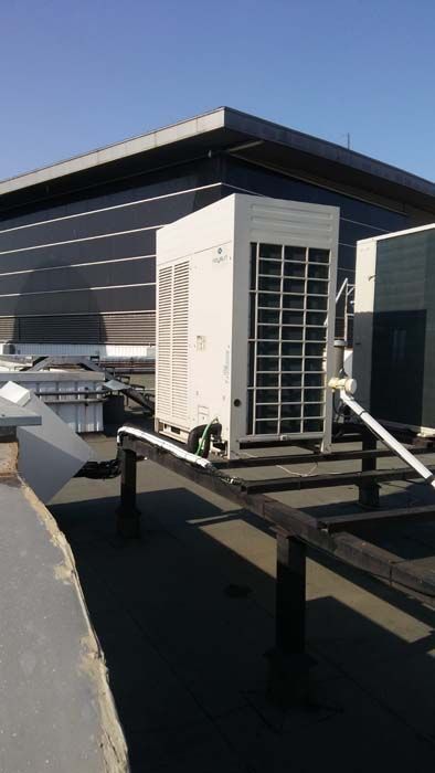 Un gran acondicionador de aire está situado en el techo de un edificio.