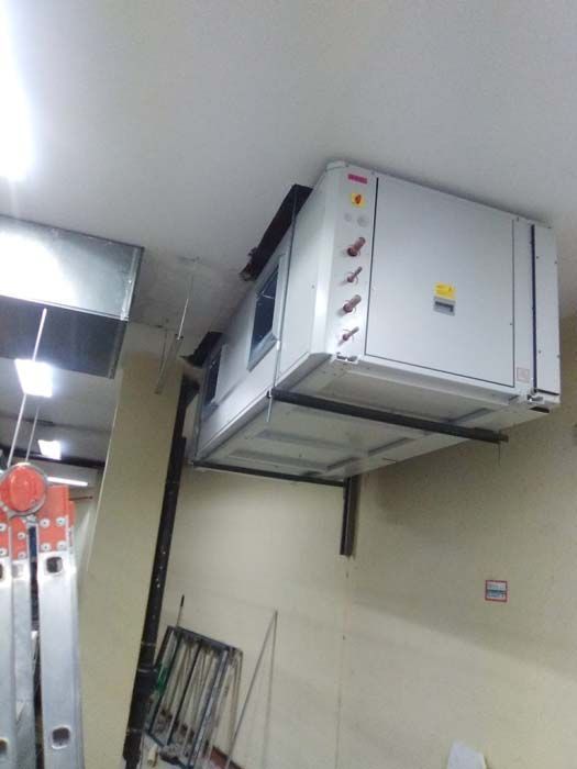 Una gran caja blanca cuelga del techo de una habitación.