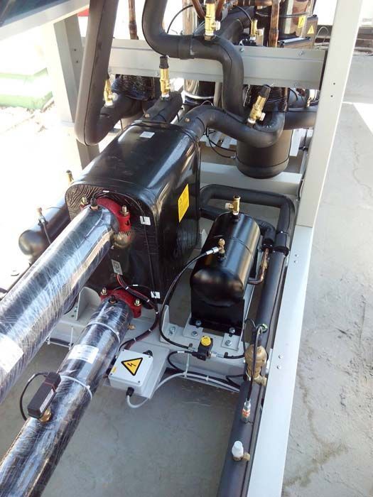 Un primer plano de una máquina con tuberías y un compresor.