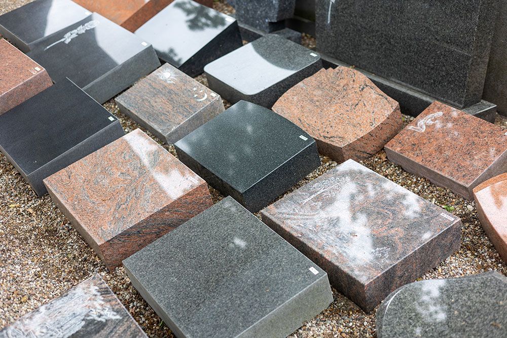 Auf dem Boden liegen viele verschiedene Arten von Granitplatten.