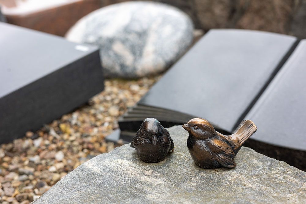 Ein paar Vogelstatuen, die auf einem Felsen sitzen.