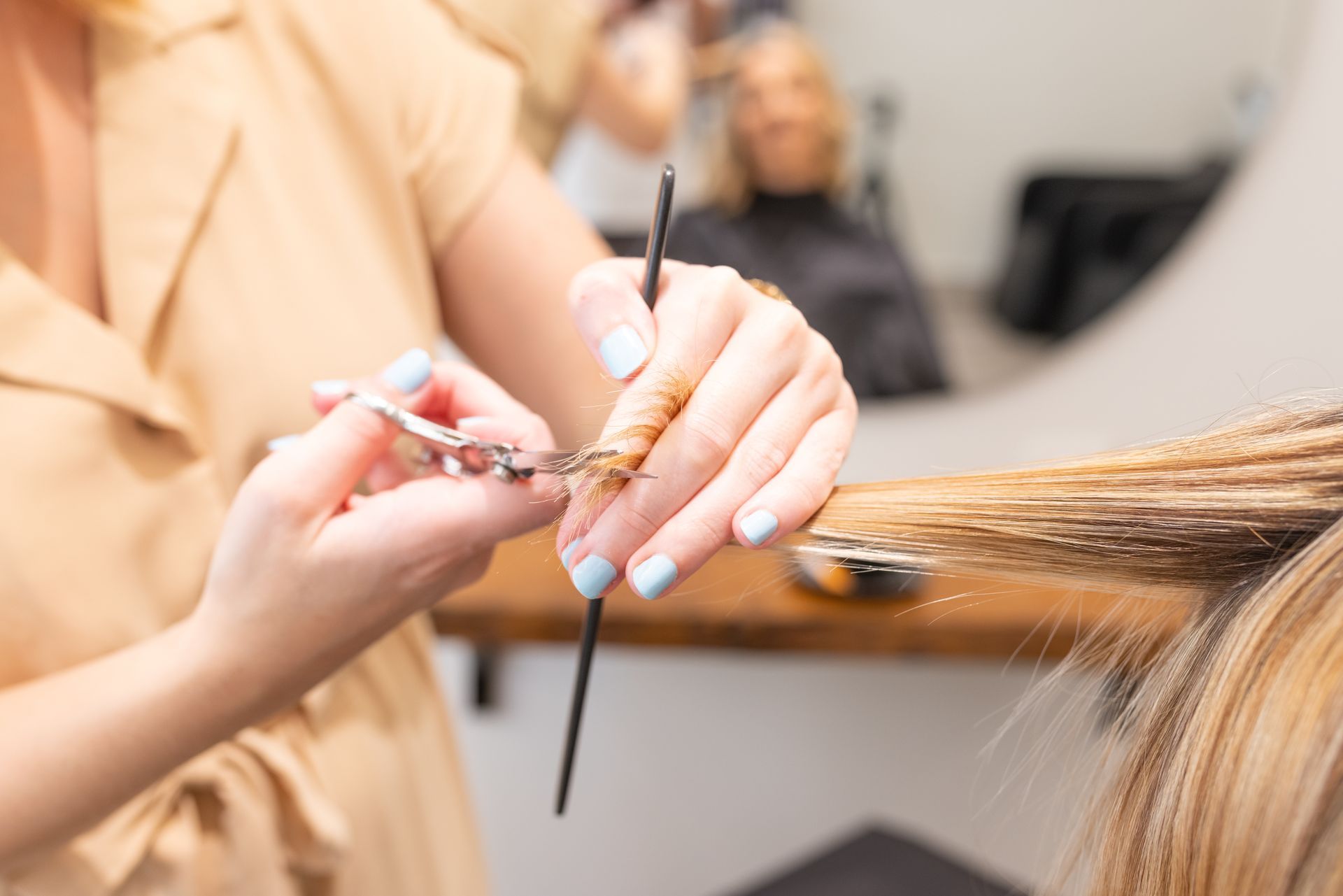 Un coiffeuse en train de couper des cheveux.