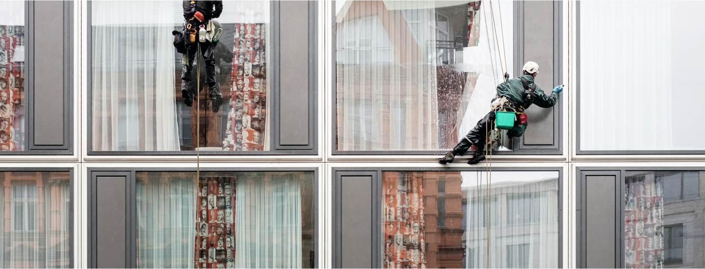 Fensterreinigung an Wohnhausfassade durch professionellen Glasreiniger.