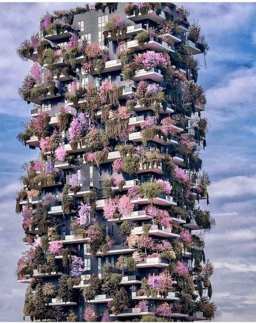 Un edificio muy alto cubierto de flores y plantas.