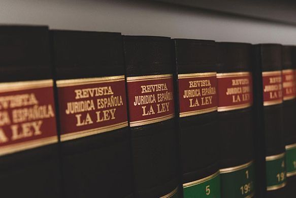 Una fila de libros jurídicos españoles están alineados en un estante.