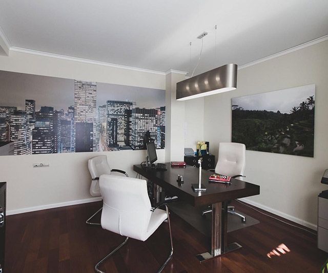 Una habitación con una mesa y sillas y una imagen de una ciudad en la pared.