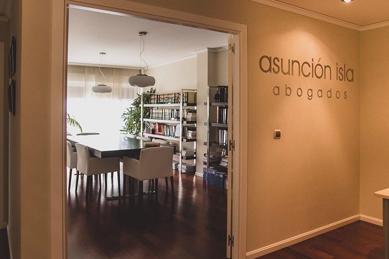 Una habitación con una mesa y sillas y un cartel en la pared.