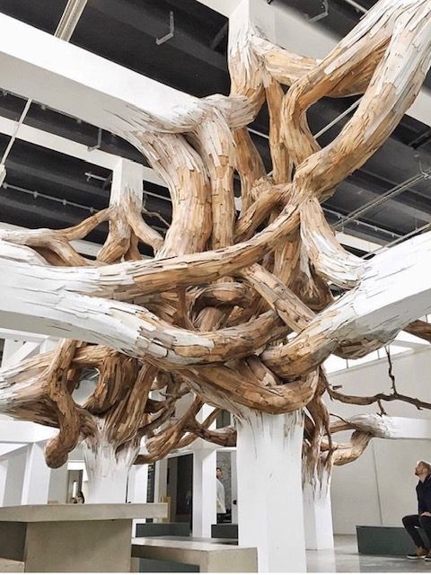 Una gran escultura de madera cuelga del techo de un edificio.