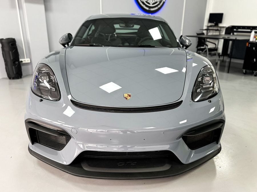 Ein grauer Porsche steht in einer Garage.