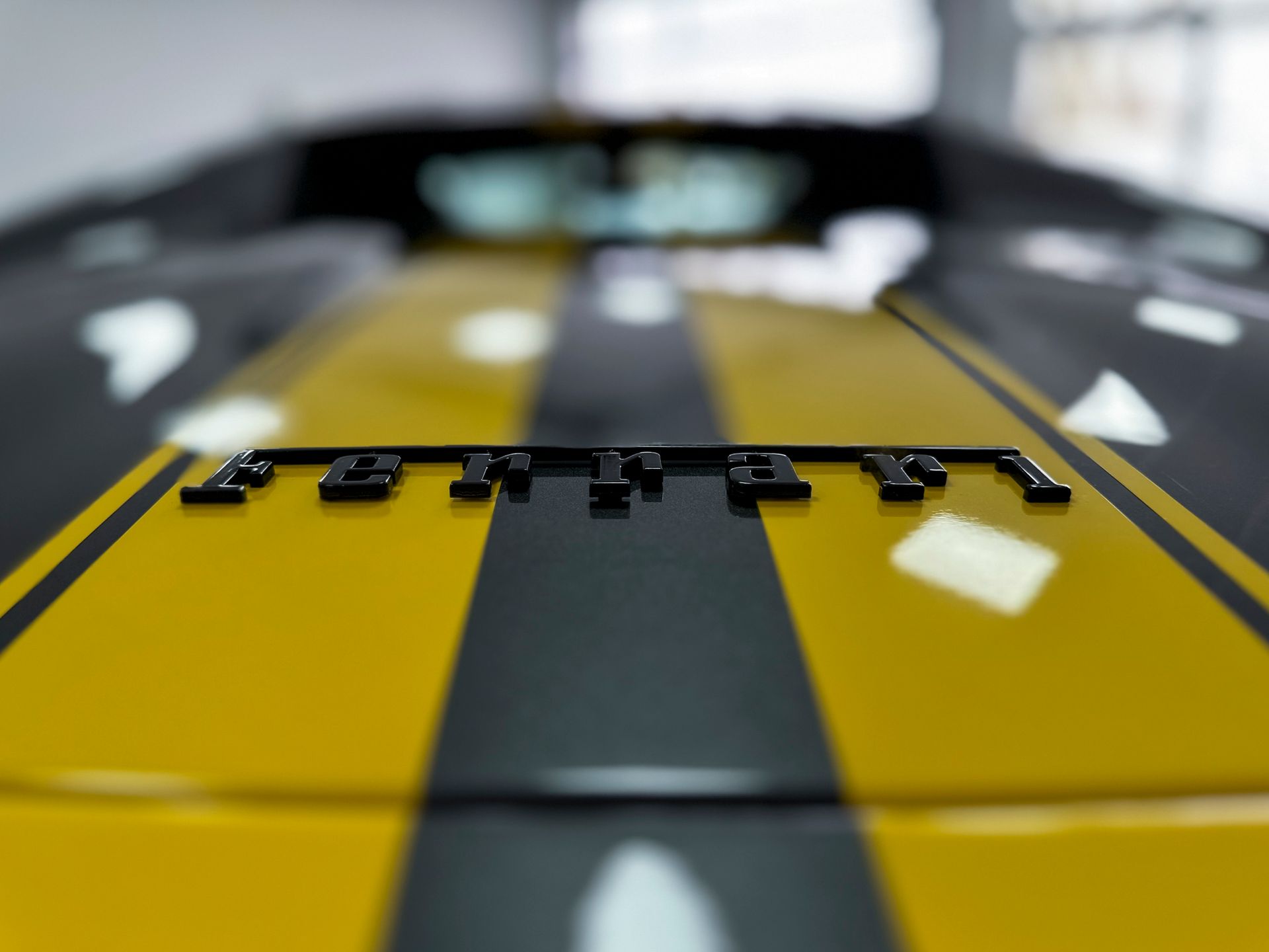 Eine Nahaufnahme der Motorhaube eines gelb-schwarzen Sportwagens.