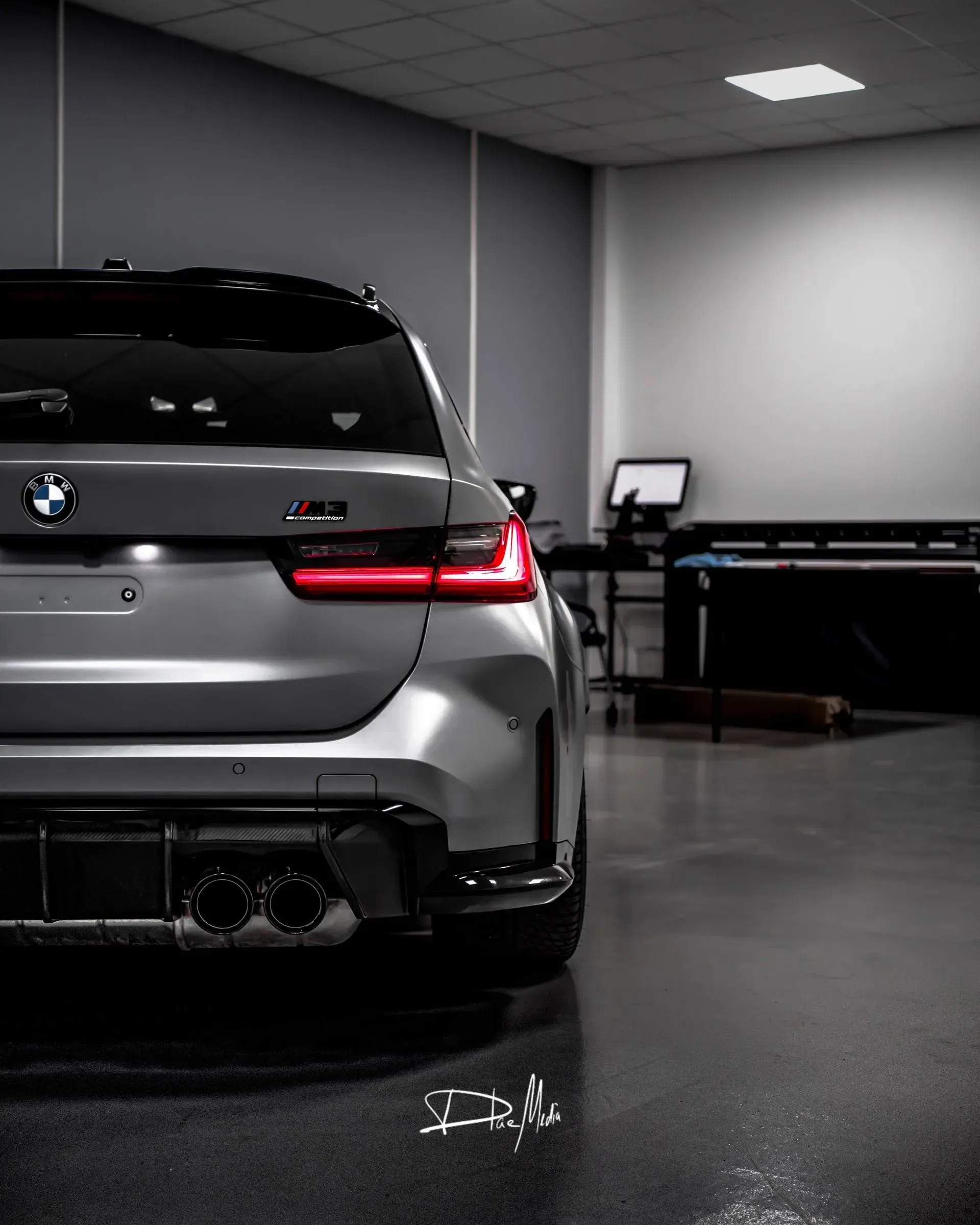 Ein silberner BMW steht in einer Garage.