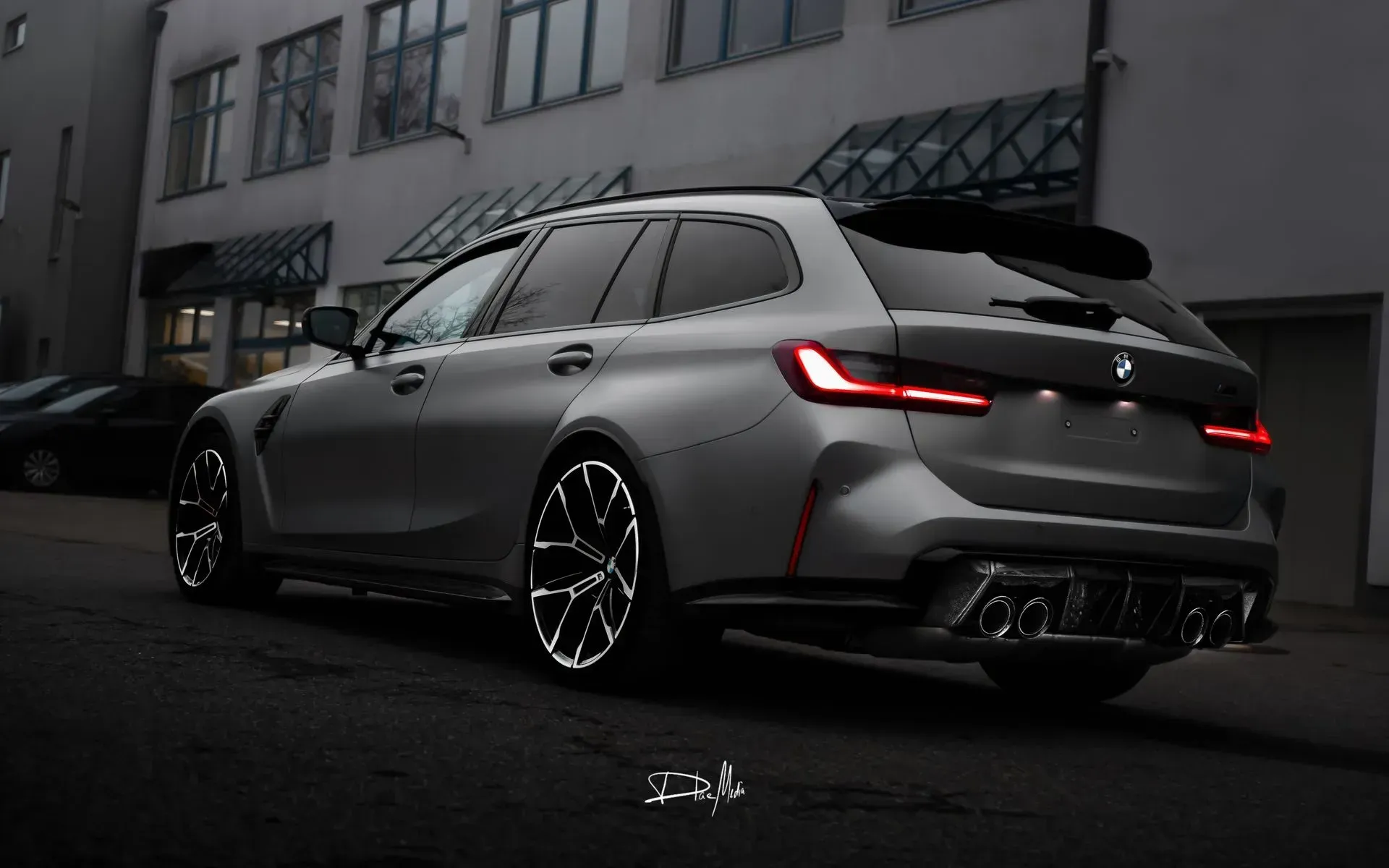 Vor einem Gebäude parkt ein BMW M3 Touring.