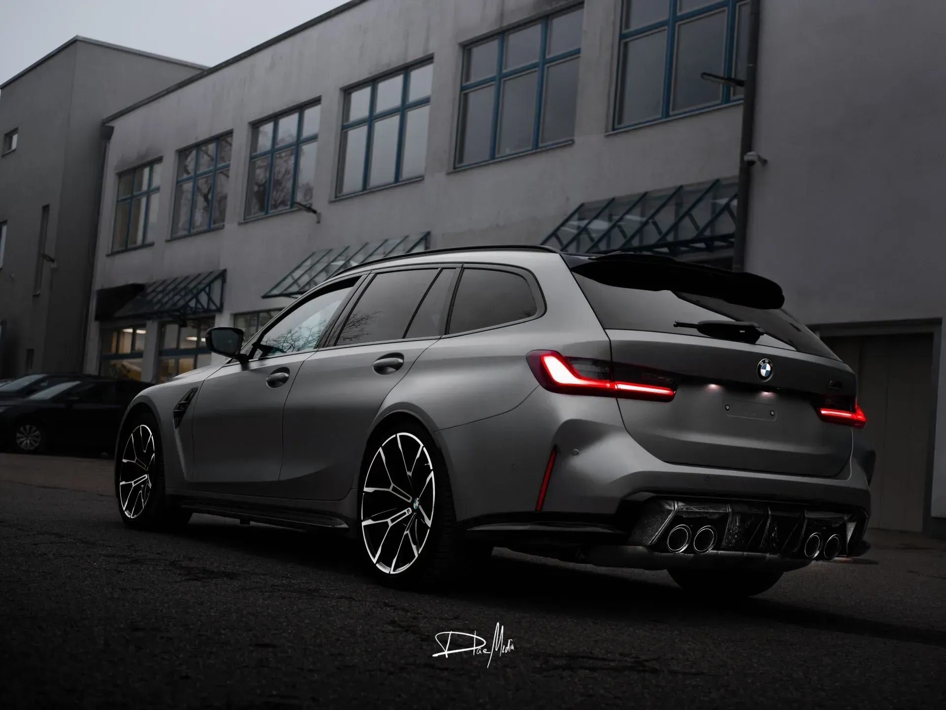 Vor einem Gebäude parkt ein BMW M3 Touring.