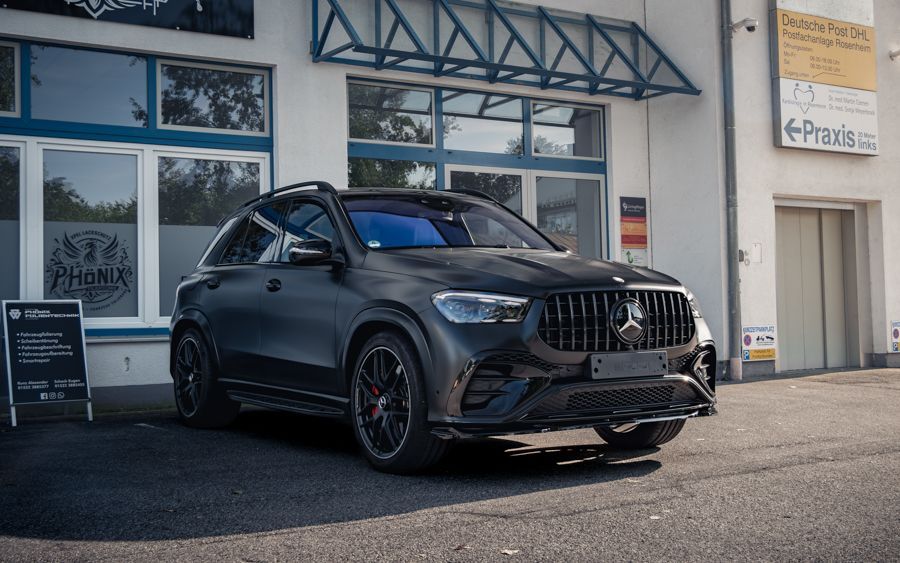 Ein schwarzes Auto parkt vor einem Gebäude.