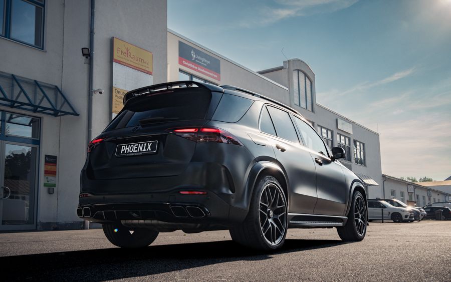 Ein schwarzer Geländewagen parkt vor einem Gebäude.