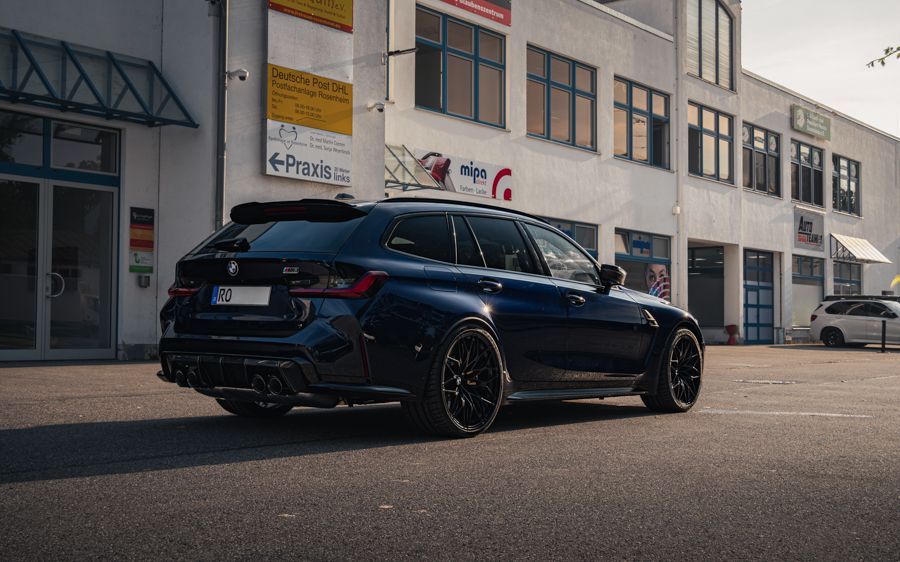 Vor einem Gebäude parkt ein blauer BMW 3er Touring.