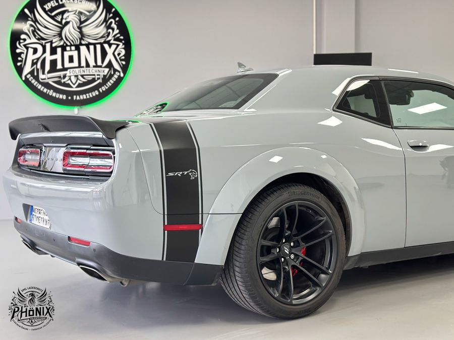 Ein grauer Dodge Challenger steht in einer Garage.