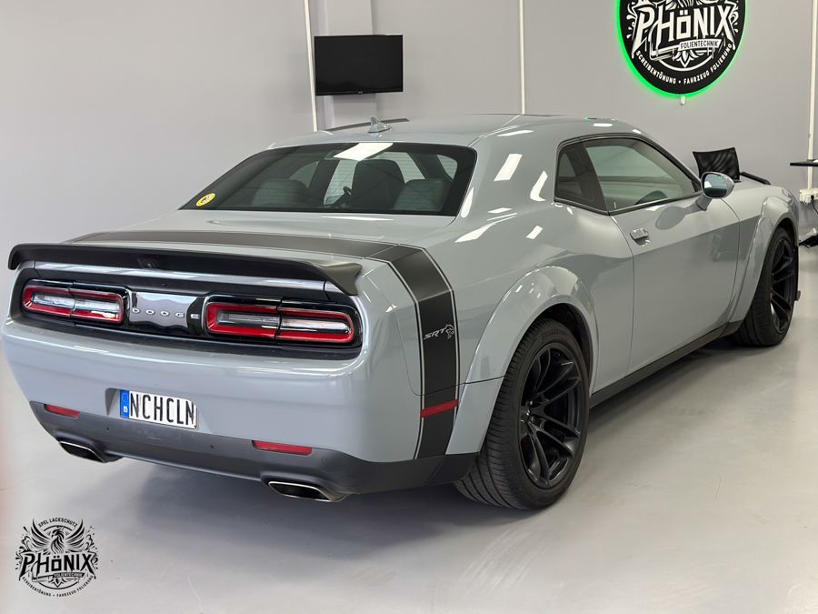 Ein grauer Dodge Challenger steht in einem Ausstellungsraum.