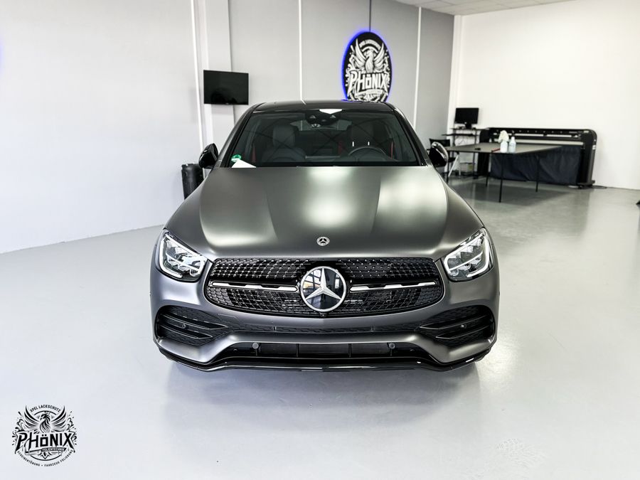 Die Front eines Mercedes Benz ist mit satiniertem schwarzem Vinyl umhüllt.