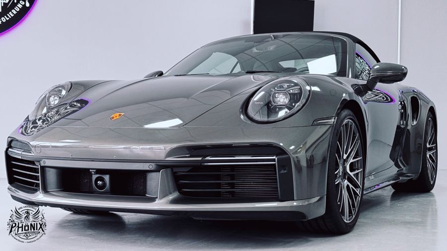 Ein grauer Porsche 911 Turbo S steht in einer Garage.