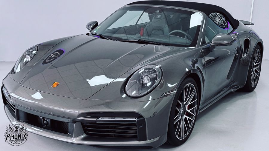 Ein graues Porsche 911 Turbo S Cabrio steht in einer Garage.