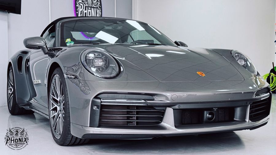 Ein grauer Porsche 911 Turbo S steht in einer Garage.