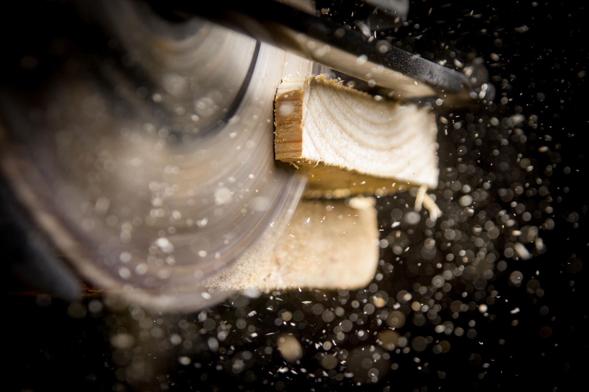 Eine Kreissäge schneidet ein Stück Holz.