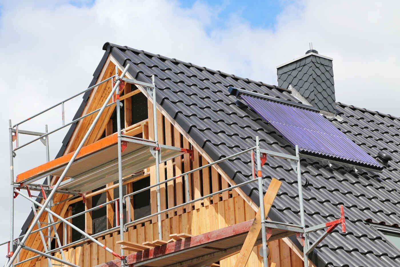 Es wird ein Haus gebaut, das von einem Gerüst umgeben ist.