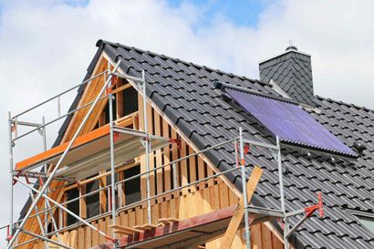 Es wird ein Haus gebaut, das von einem Gerüst umgeben ist.