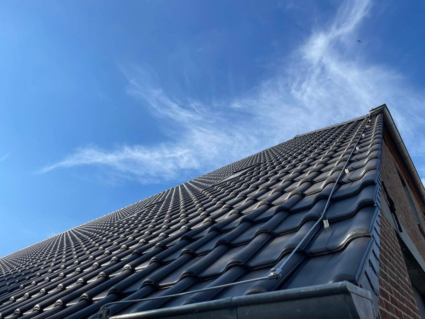 Blick auf ein Dach mit blauem Himmel im Hintergrund
