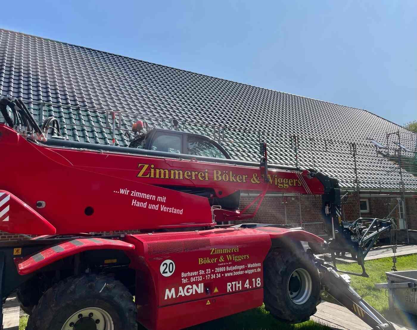 Vor einem Gebäude parkt ein roter Traktor.