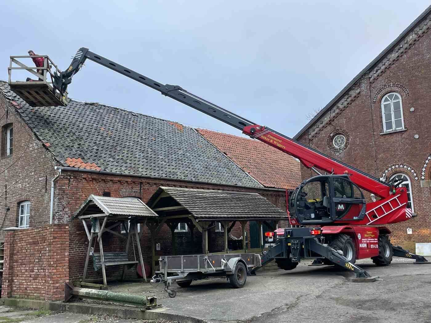 Auf einem Backsteingebäude steht ein Kran.