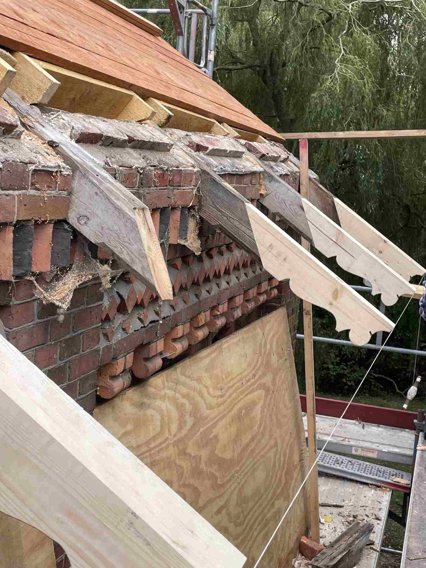 Es wird ein Dach aus Holzbalken und Ziegeln gebaut.