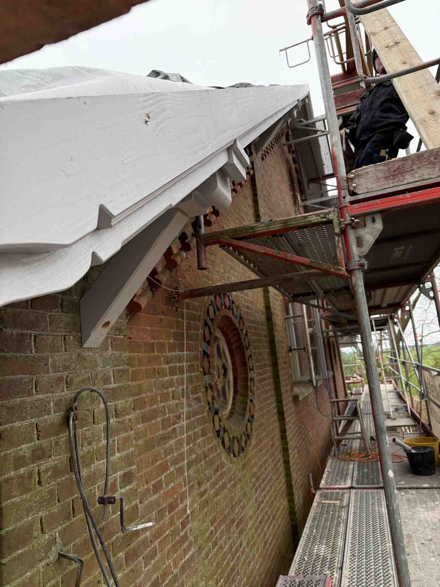 Ein Backsteingebäude mit einem Gerüst an der Seite.