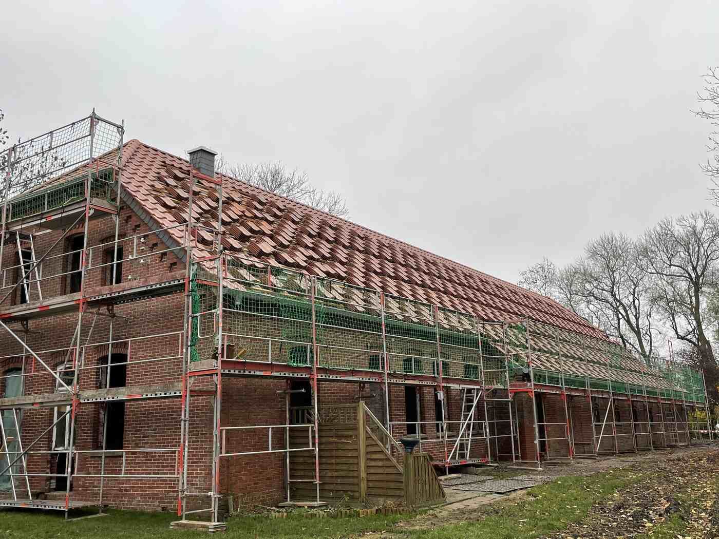 Ein großes Backsteingebäude im Bau, umgeben von einem Gerüst.