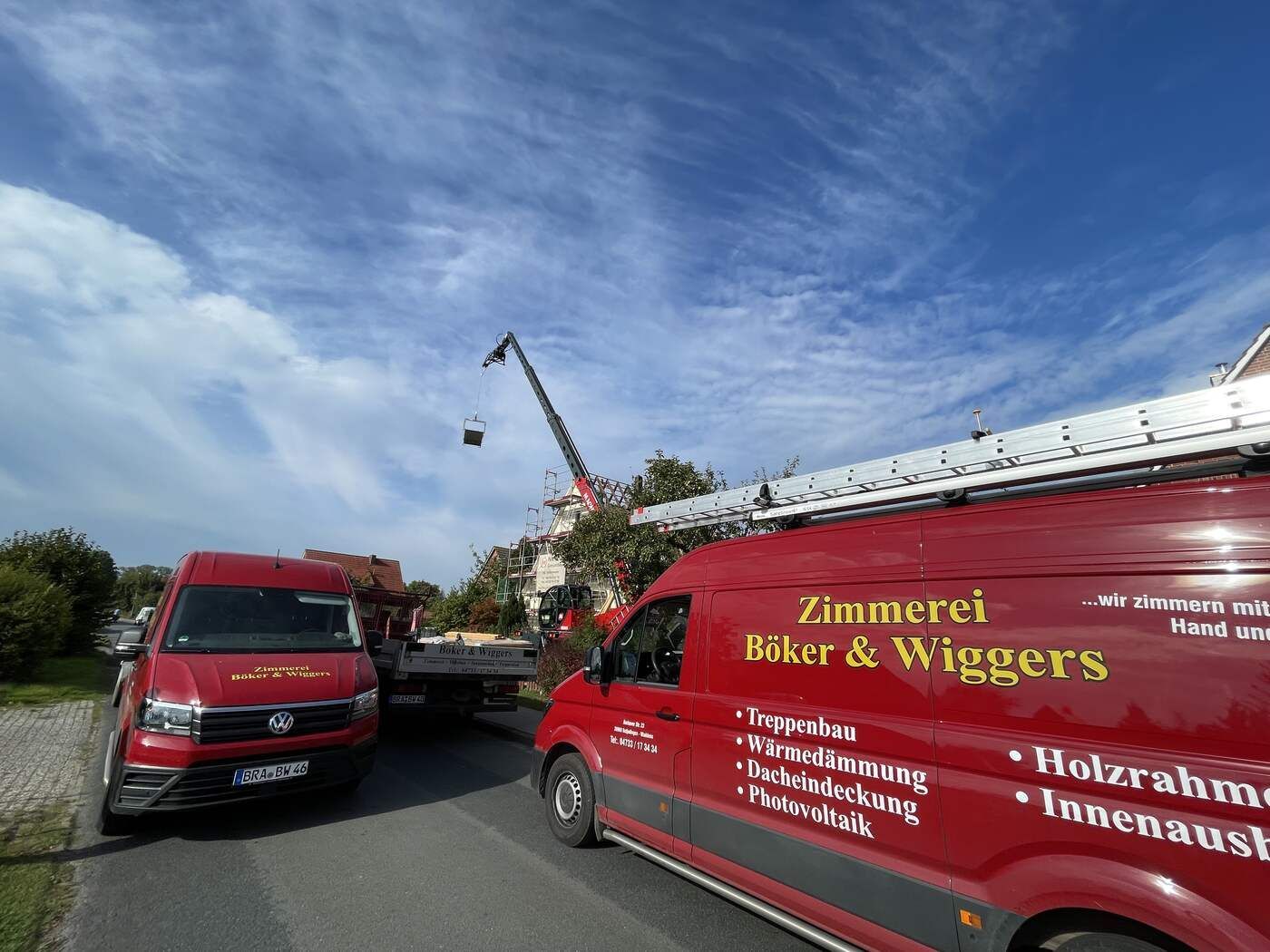 Zwei rote Lieferwagen parken am Straßenrand.