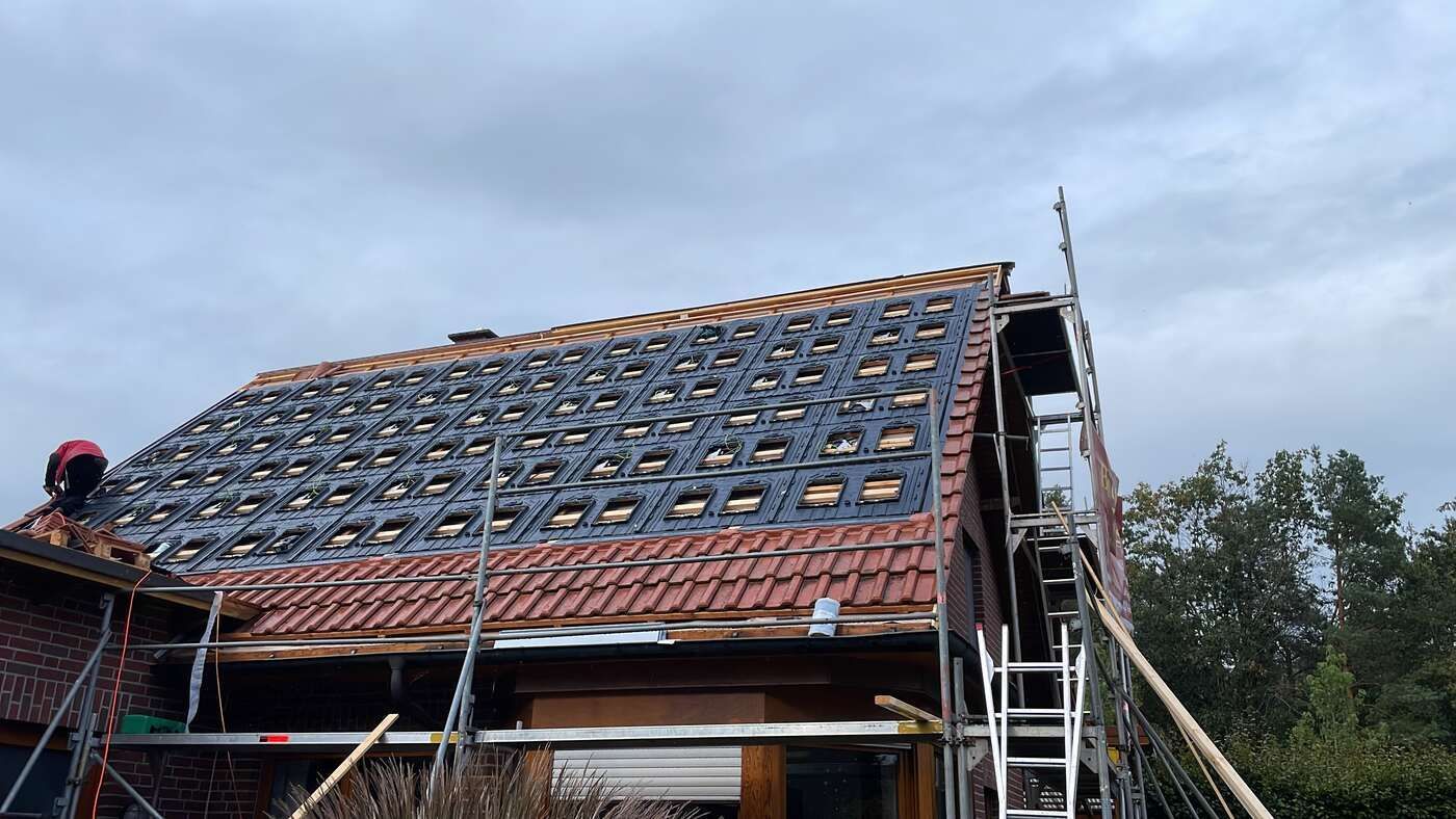 Ein Haus mit Ziegeldach wird umgebaut.