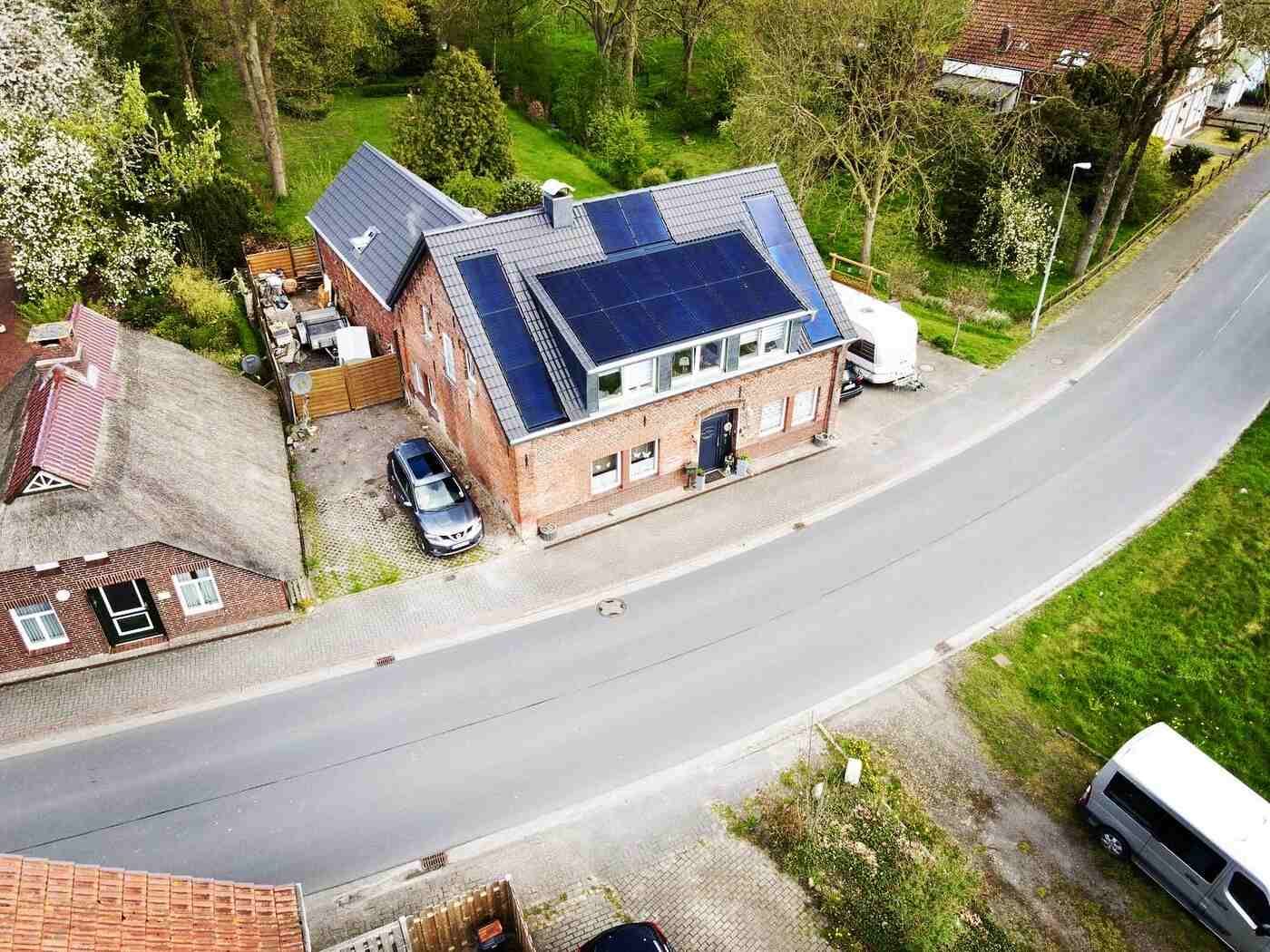 Eine Luftaufnahme eines Hauses mit Solarmodulen auf dem Dach.