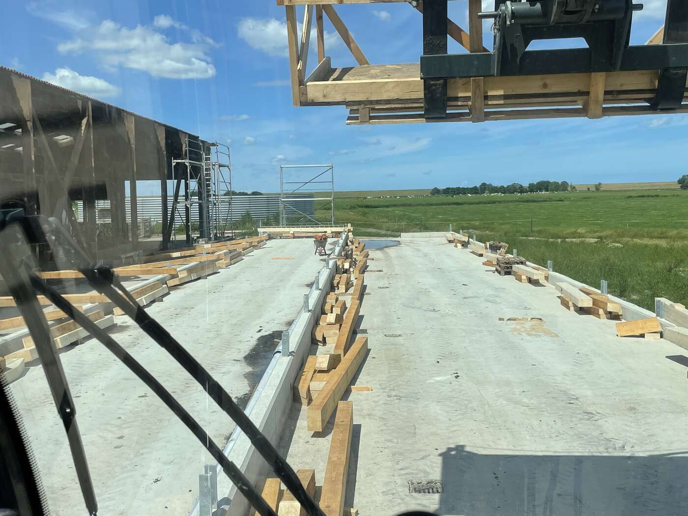 Ein Blick durch die Windschutzscheibe eines Lastwagens auf eine im Bau befindliche Brücke.